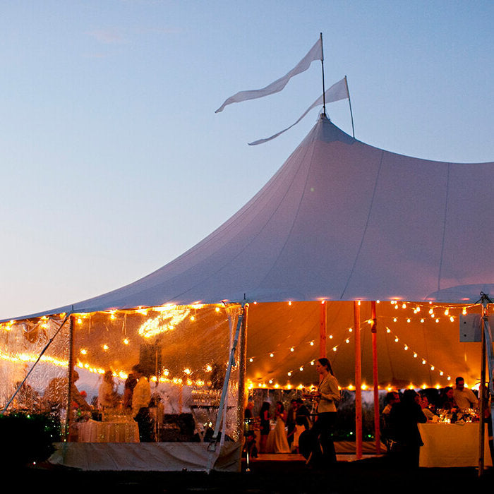 Sailcloth Event Tent by Canvas Camp Luxury Outdoor Canopy at sunset with lights