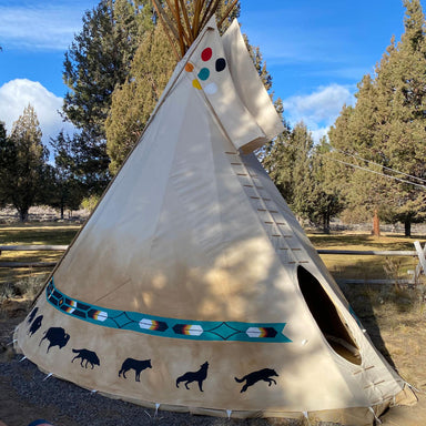 Teepee Tent by Nomadic Tipi Makers Native Artist Creations design on gravel near trees