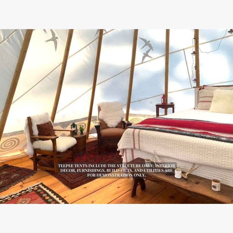 Teepee Tent by Nomadic Tipi Makers interior view with bed two chairs and wood flooring