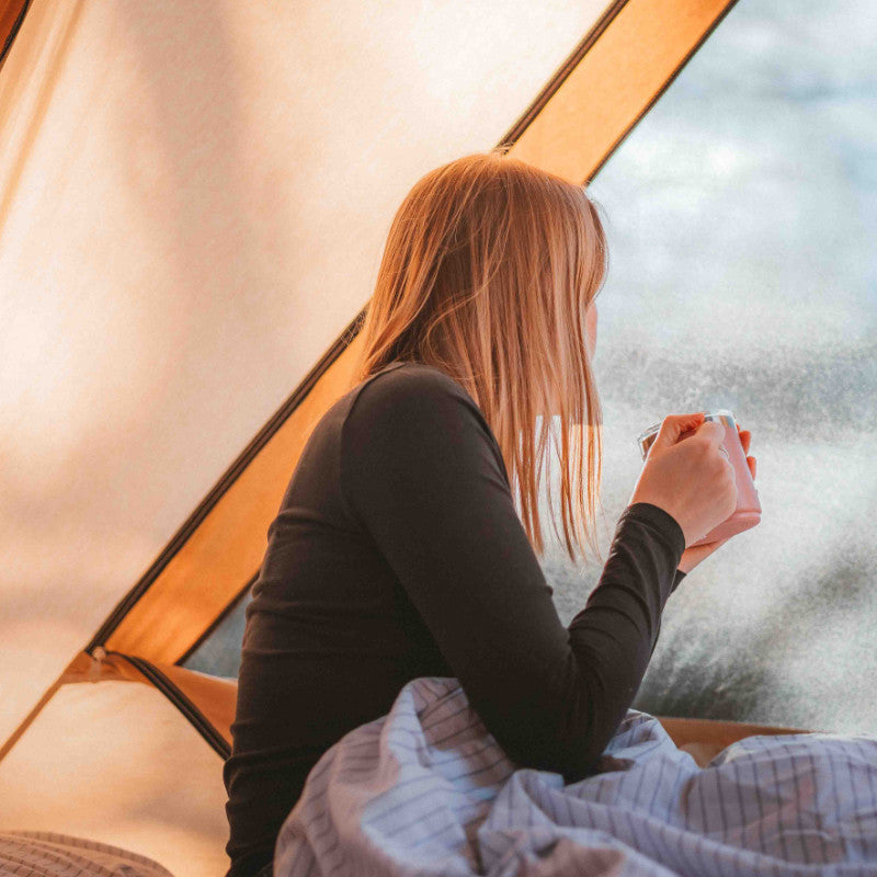 A Frame Tent Big Horn by Canvas Camp interior view woman drinking coffee