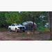 RBM Koala Hub khaki at campsite in woods with white truck