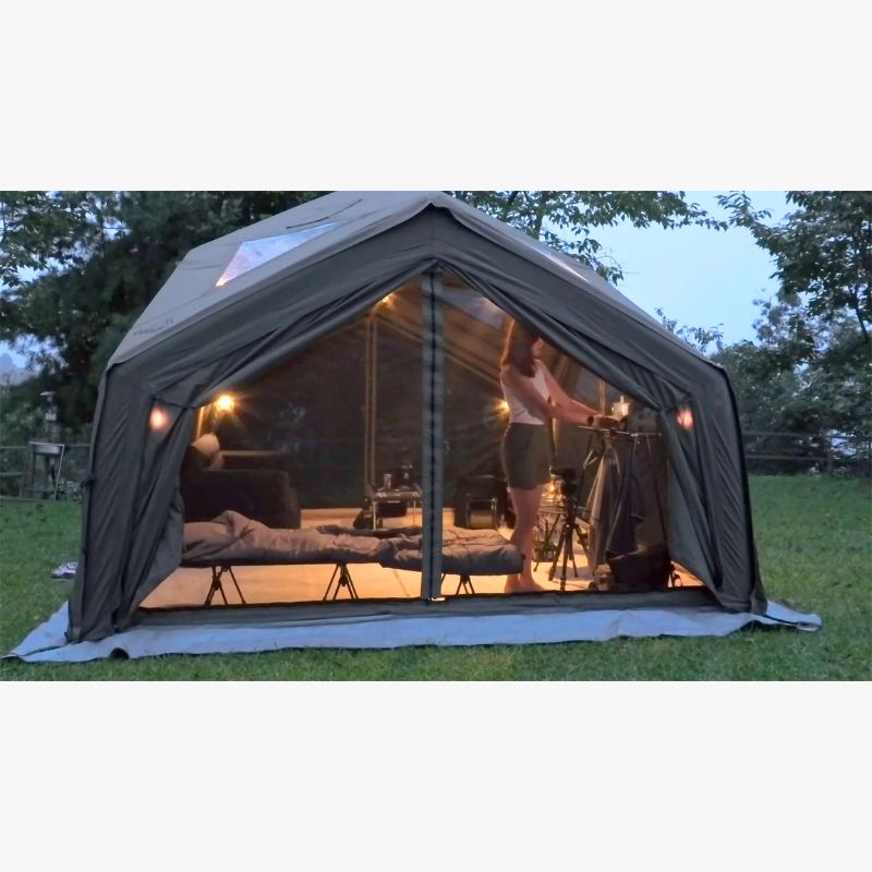 RBM Koala Hub khaki at dusk with lights on closed mesh door and woman