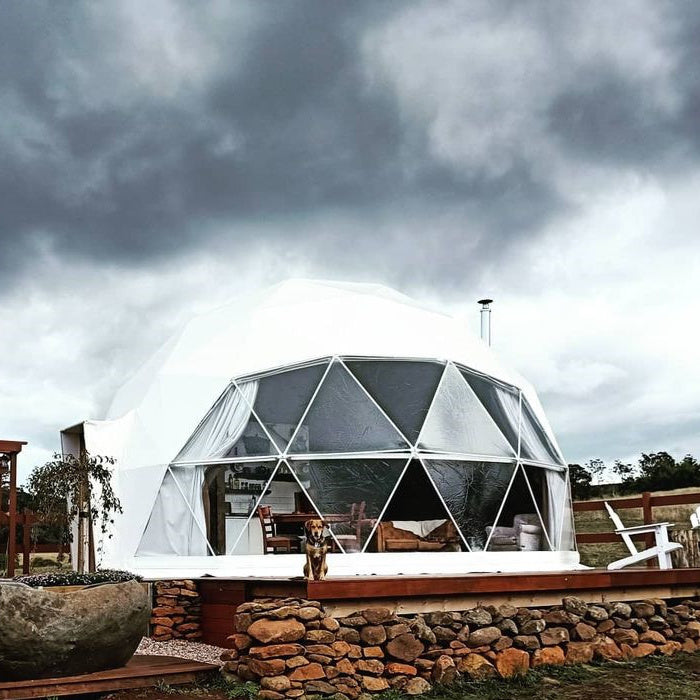 Stargazing Dome 19' Luna Glamping in white by stone wall