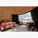 Stargazing Dome 23' Luna Glamping interior view with bed and two chairs by front window