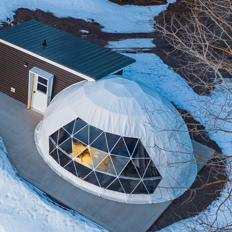 Stargazing Dome 23' Luna Glamping white in woods with snow on concrete slab