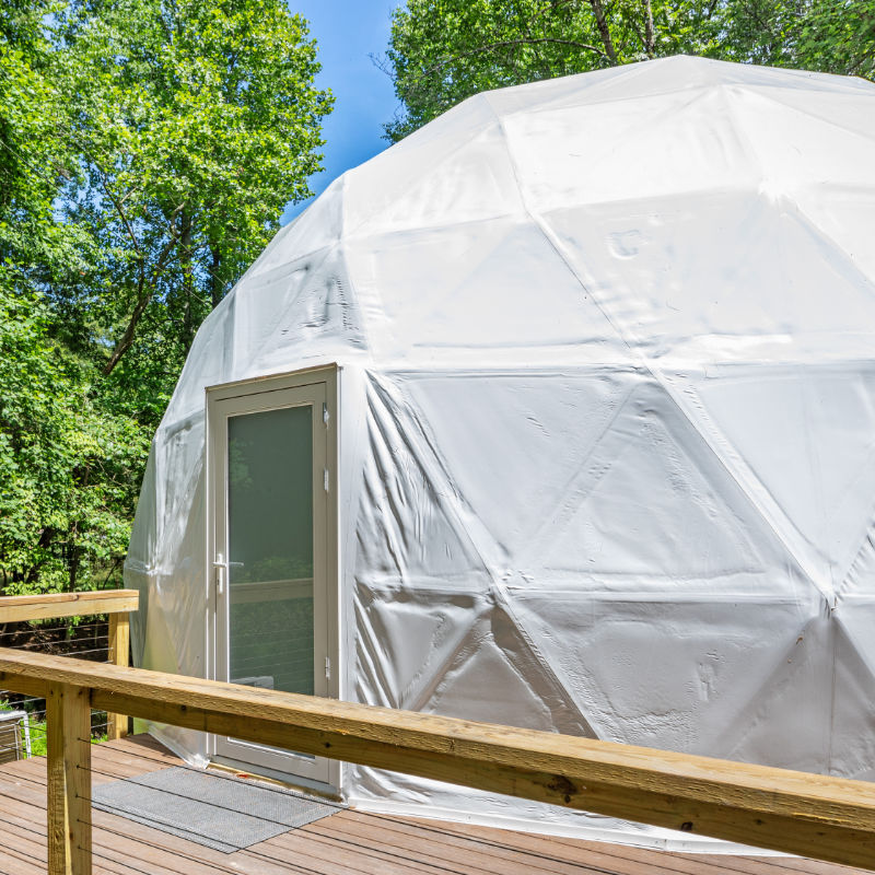 Stargazing Dome 26' Luna Glamping in white front entrance view on wood deck in forest