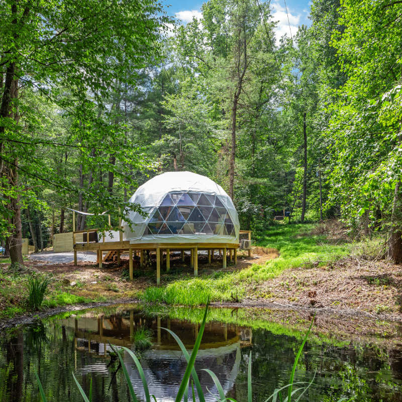Stargazing Dome 26' Luna Glamping in white on wood deck by pond