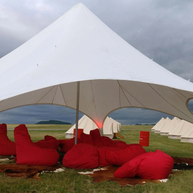 Starshade Event Tent by CanvasCamp  Luxury Outdoor Canopy close up with red bean bag chairs on grass