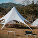 Starshade Event Tent by CanvasCamp  Luxury Outdoor Canopy during the day with tables and chairs on brown grass