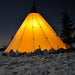 Teepee Tent Tipi 600 by Canvas Camp at night with light on in snow