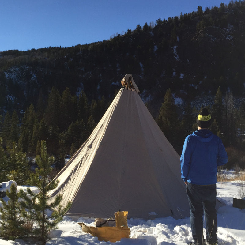Teepee Tent Tipi 600 by Canvas Camp on snow with man in blue jacket sunny day