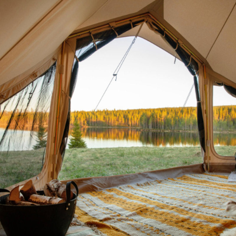 Yurt Tent Sibley Apex by Canvas Camp view out front door to lake water and trees with rug