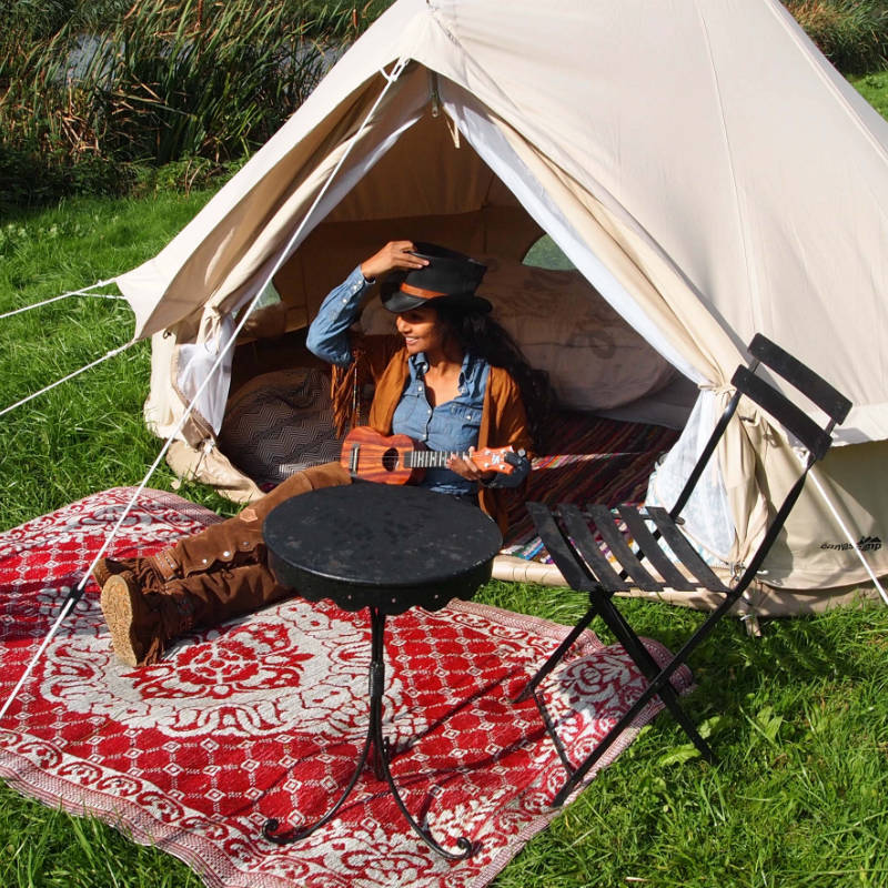 Yurt Tent Sibley Ultimate 300 by Canvas Camp woman sitting in doorway with red rug playing ukulele guitar instrument