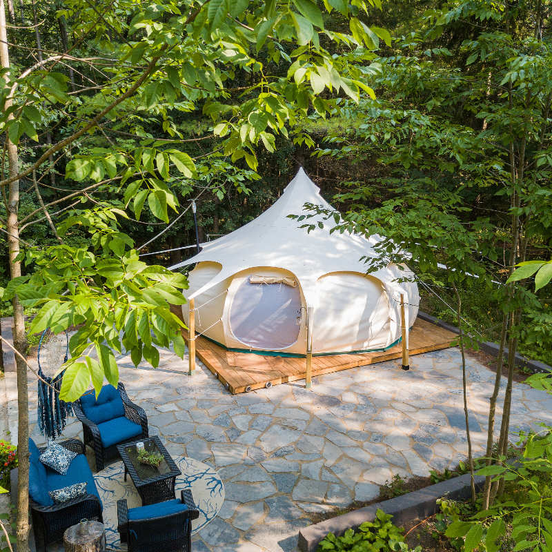 Yurt Tent Temple Apex by Canvas Camp far birds eye view drone view on wood platform in forest